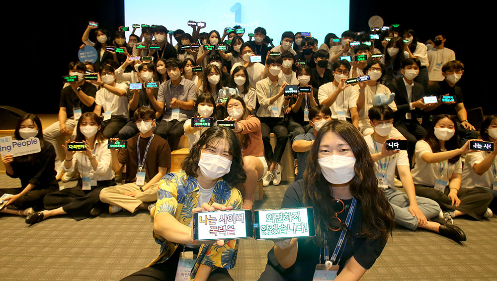 삼성전기 신입사원이 입사 1주년 행사에서 사이버 폭력 근절을 위한 '비폭력 지지 서명'을 하고있다.